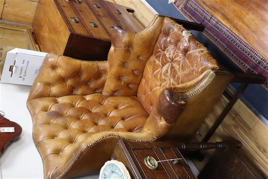 A pair of leather tan wing armchairs